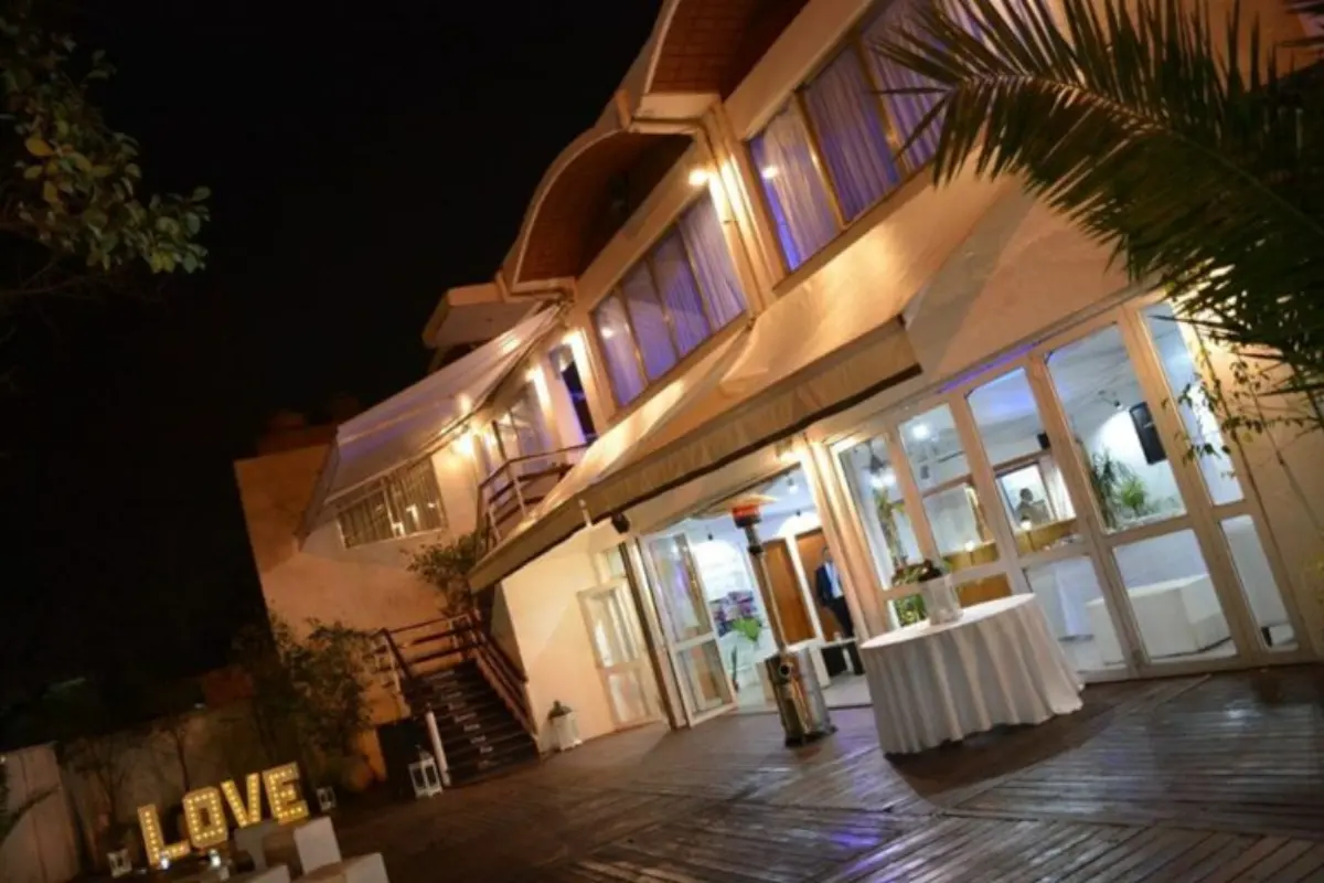 Frente del salón iluminado de noche con letras luminosas LOVE en el jardín