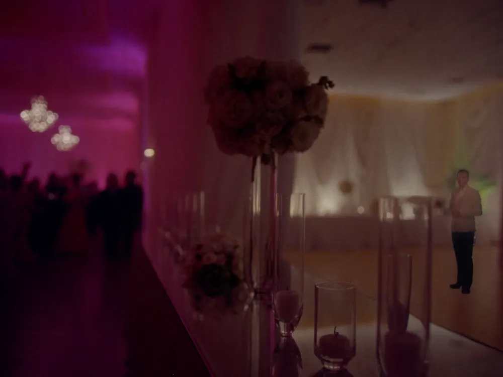 Centro de mesa con flores blancas y velas sobre mesa espejada con luz cálida